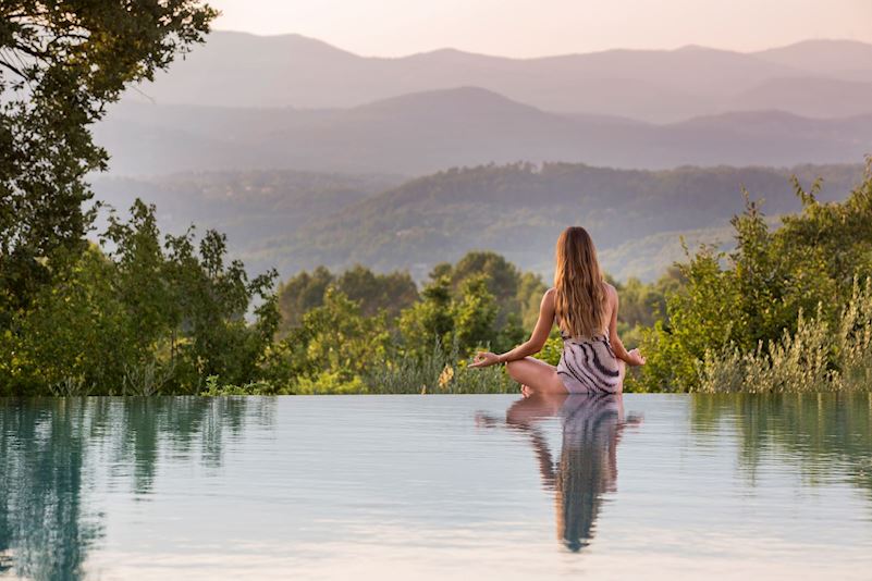 Personne en méditation au bord de la piscine à débordement Terre Blanche